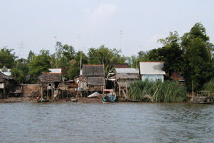 Several houses sit over or near a body of water.