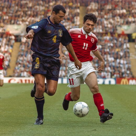 Stephane Chapuisat, rechts, bei der Fussball-Europameisterschaft 1996 im Zweikampf mit dem Schotten Colin Calderwood, links, im Vorrundenspiel der Schweiz gegen Schottland, aufgenommen am 18. Juni 1996 in Birmingham. Die Schweiz verliert das Spiel mit 0:1. (KEYSTONE/Str)