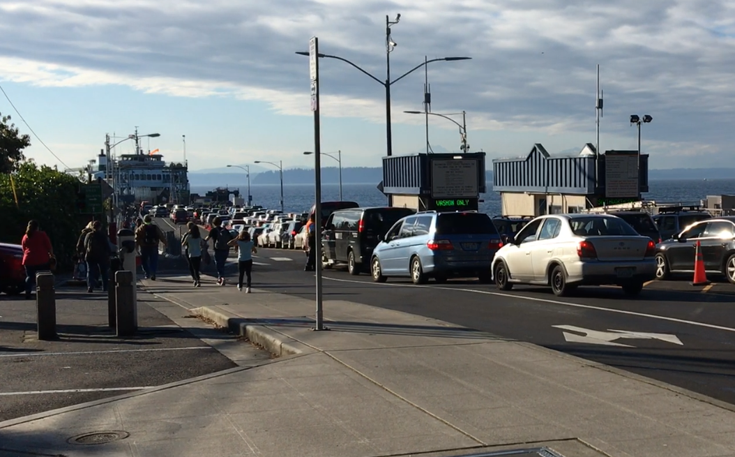 Fauntleroy terminal with a ferry at the dock and people walking to the boat and vehicles waiting