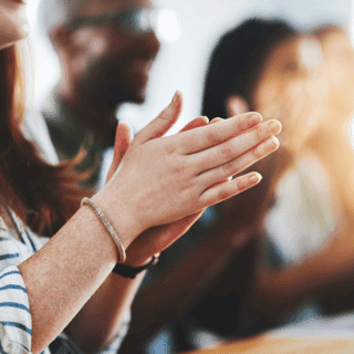 Engaged employees clapping during a work event.