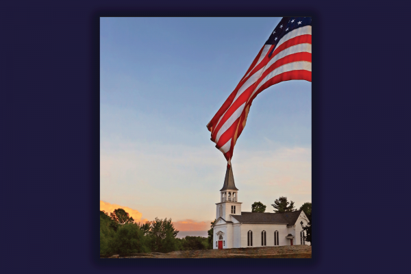 An image of a white church stands behind a fluttering American flag.