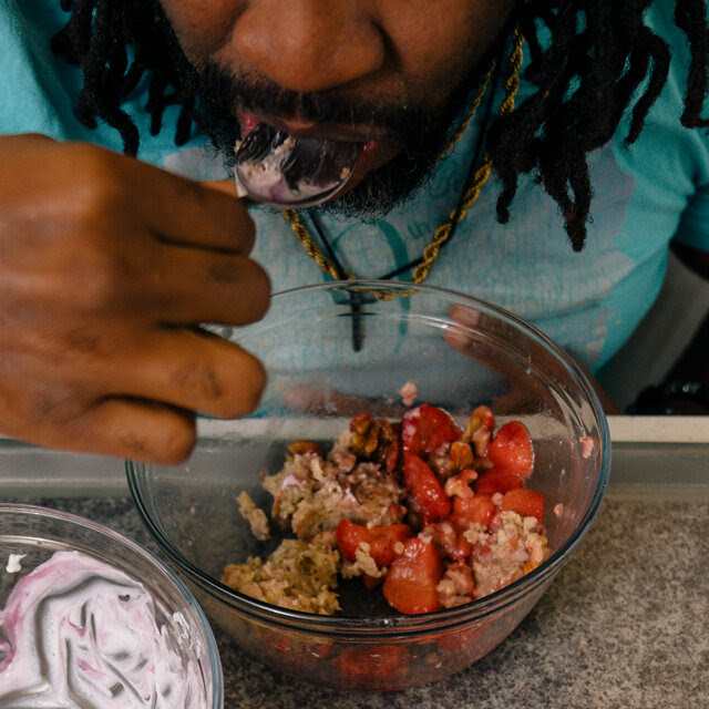 Ernest Jones III eats an entire test breakfast of yogurt, strawberries and granola.