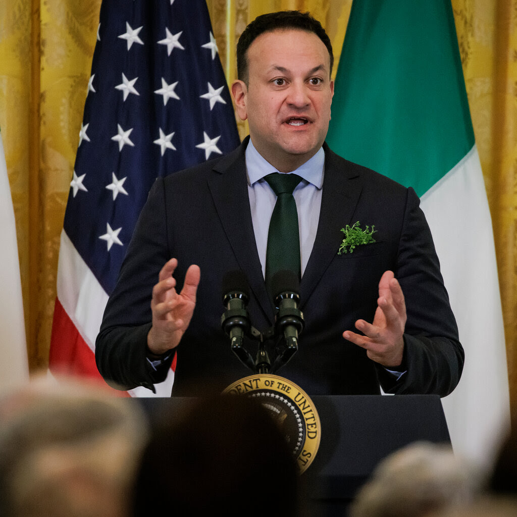 Leo Varadkar speaks behind a lectern with a United States presidential seal in front of Irish and American flags.