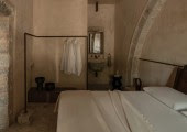 La cama se flanquea por un aseo y una bañera independiente en cada lado, reforzando la sensación de amplitud dentro de un espacio compacto.