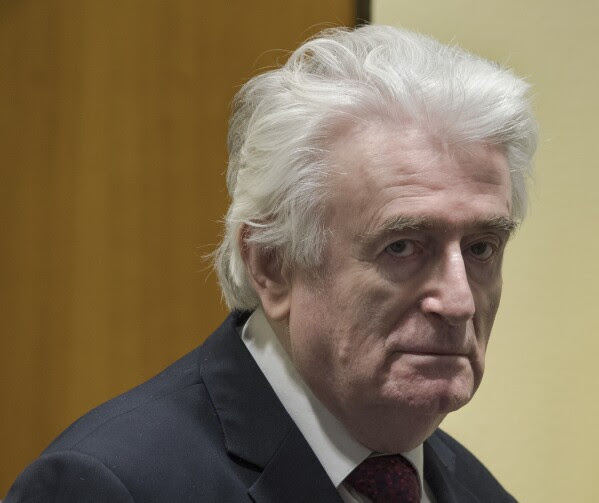 FILE - In this Wednesday, March 20, 2019 file photo, former Bosnian Serb leader Radovan Karadzic enters the court room of the International Residual Mechanism for Criminal Tribunals in The Hague, Netherlands. Karadzic, one of the chief architects of the slaughter and devastation of Bosnia's 1992-95 war, was convicted in 2016 by a United Nations court of genocide, crimes against humanity and war crimes. (AP Photo/Peter Dejong, file)