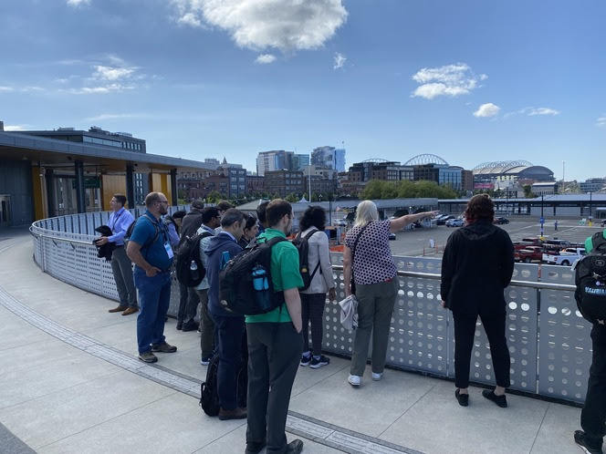 Several people on an elevated walkway looking out at the area below