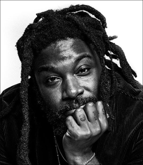 Jason Reynolds looking into camera with chin resting on hand