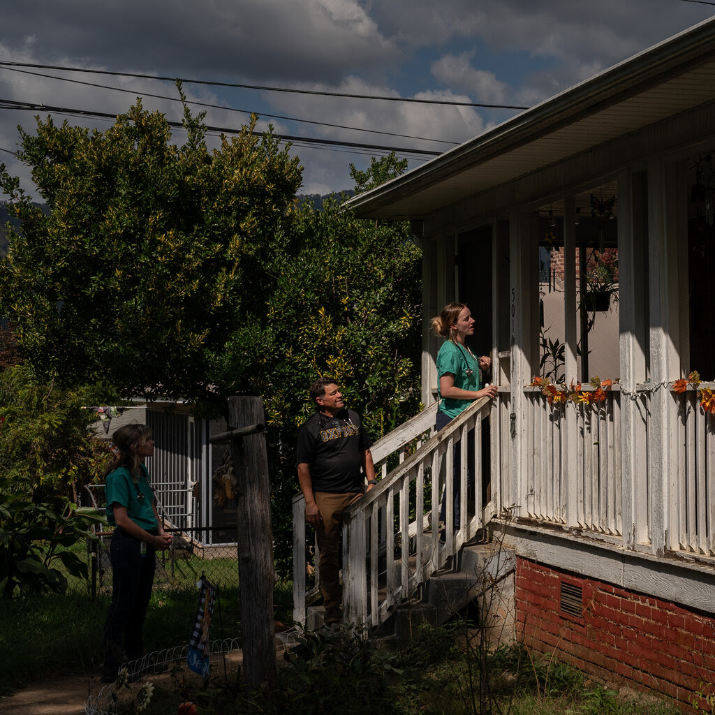 People climb steps up to a house. 