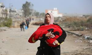 Una mujer huye del barrio de Al Zeitoun en la ciudad de Gaza, al sur de la Franja de Gaza.