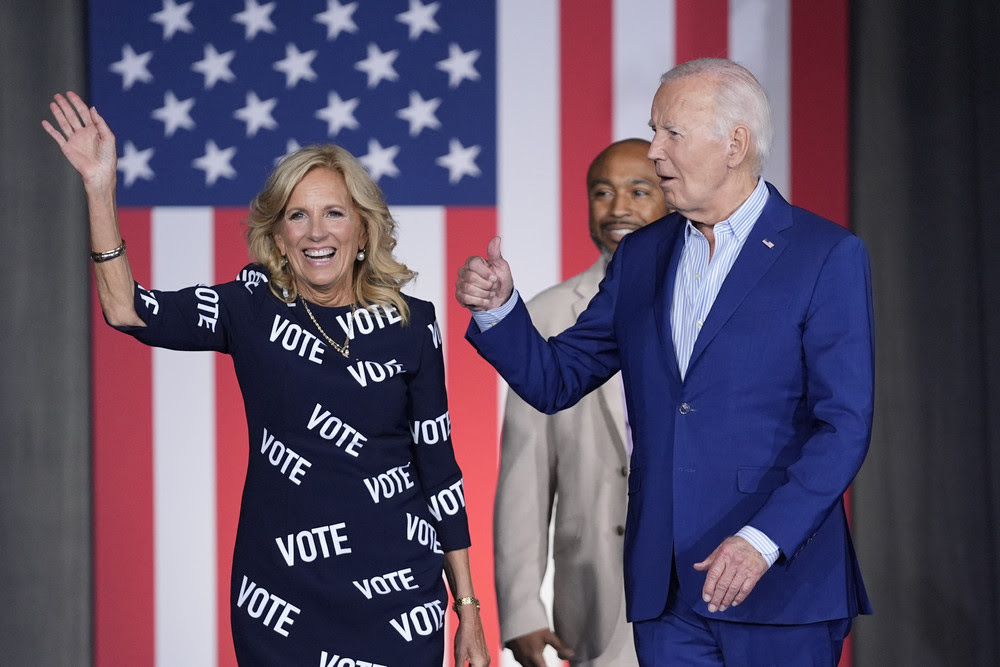 President Joe Biden, right, and first lady Jill Biden, left, walk to the stage to speak at a campaign rally, joined in background by Eric Fitts, Friday, June 28, 2024, in Raleigh, N.C.
