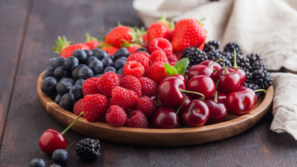 A wooden bowl filled with mixed berries, which helps reverse prediabetes