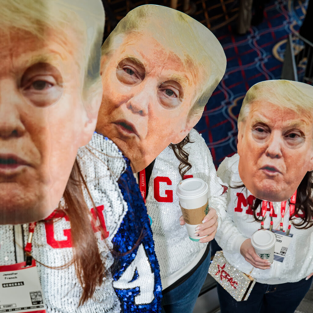 Three people wearing Donald Trump masks.