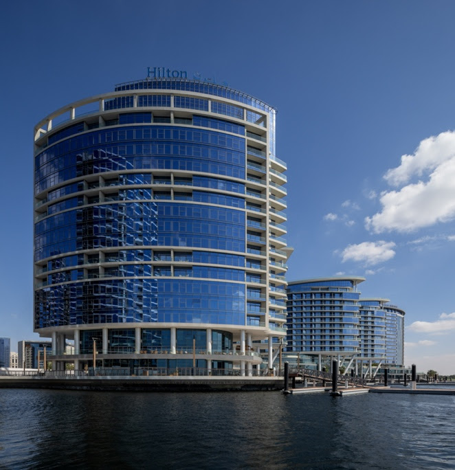 A group of buildings next to waterDescription automatically generated