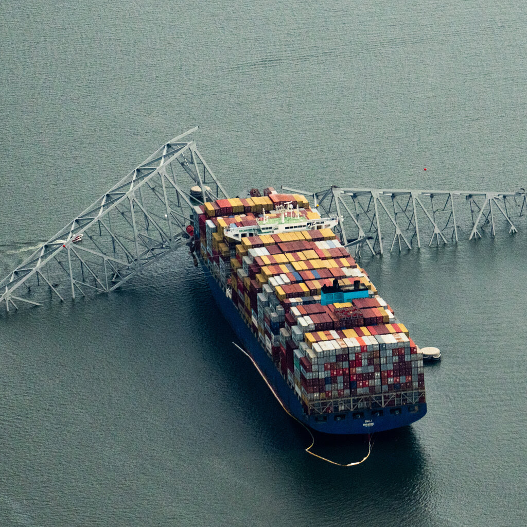 The Dali container ship with a large section of a bridge resting on its bow.