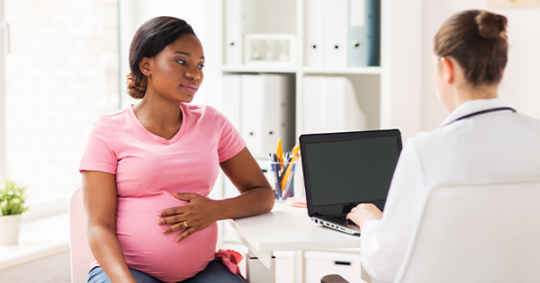 Pregnant woman speaking to a doctor.