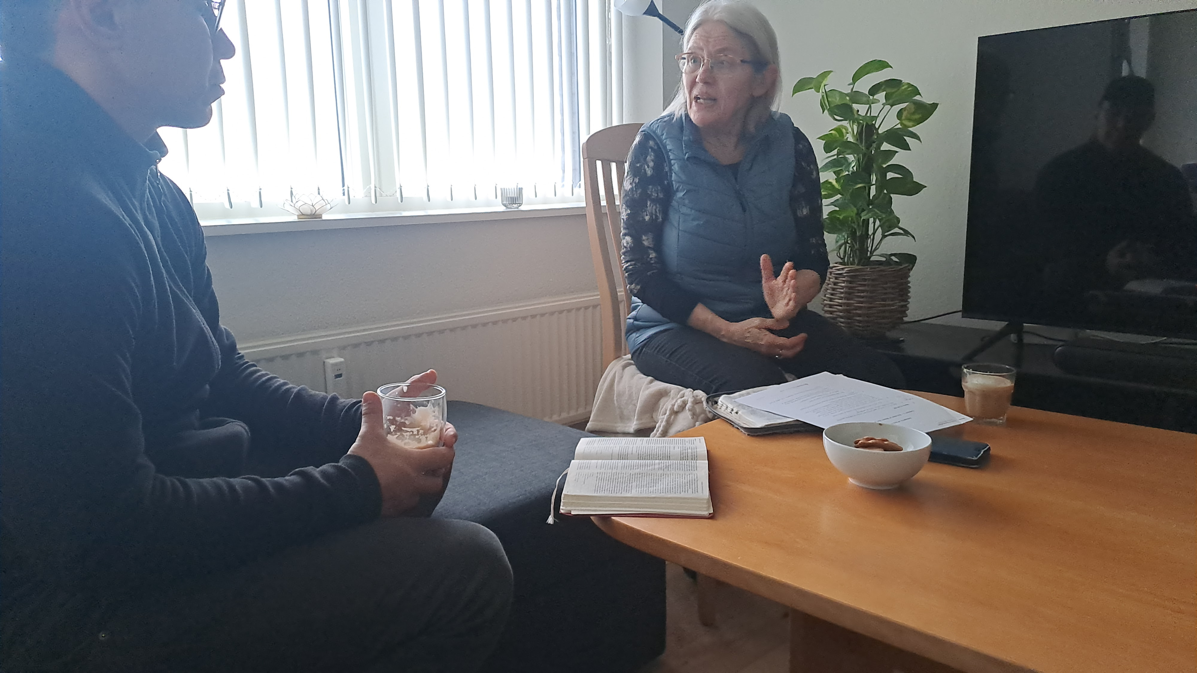 a man and a woman sitting around a table talking