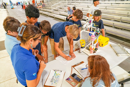 People at a table weighing their underwater robot
