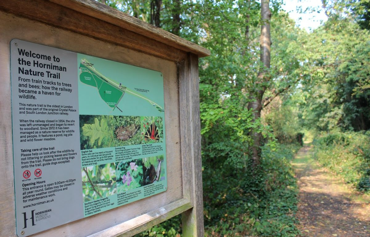 A view of a welcome sign on the Nature Trail and the Trail in the distance