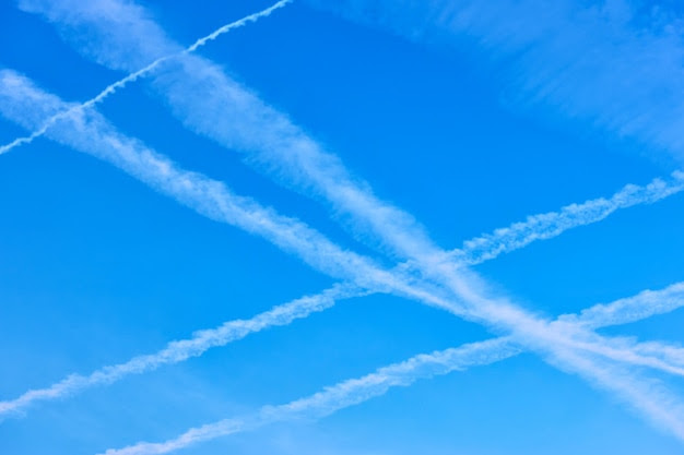 Crossing airplane trails in the blue sky