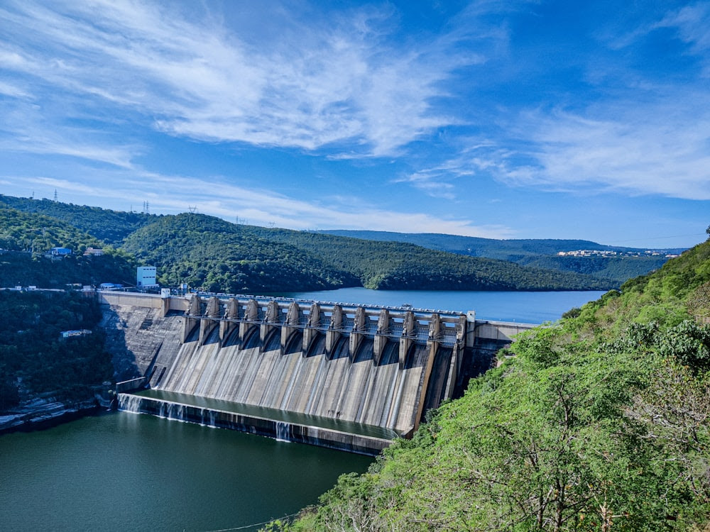 barrage en béton gris sous le ciel bleu pendant la journée