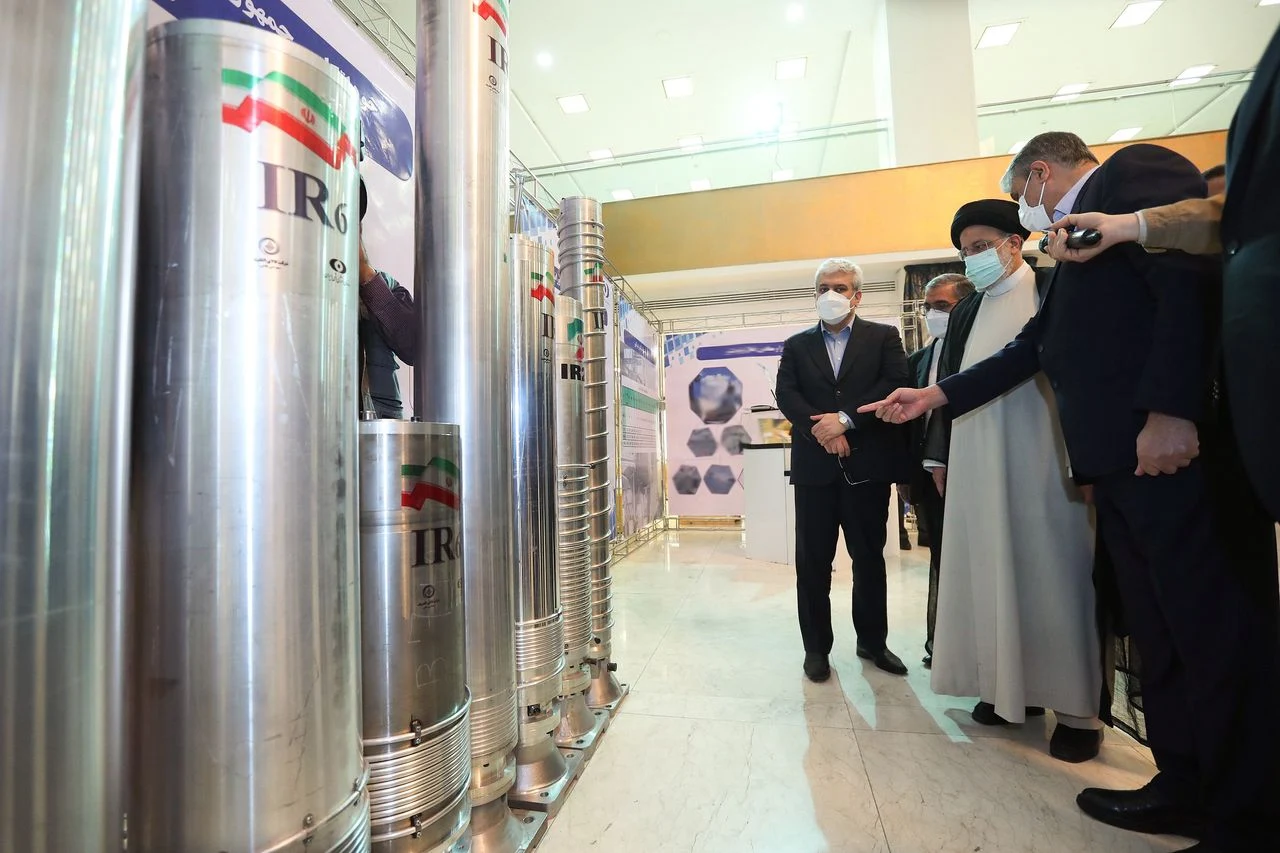 Mohammad Eslami, head of the Atomic Energy Organization of Iran, shows Iranian President Ebrahim Raisi nuclear centrifuges during an April 2022 exhibition in Tehran. (Iranian Presidency/Anadolu Agency/Getty Images)