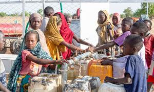 Unos niños recogen agua limpia y potable de una estación instalada por UNICEF en la aldea de Al-Serif, en Darfur.