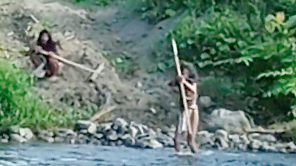 Hongana Manyawa men with weapons aim at bulldozers.