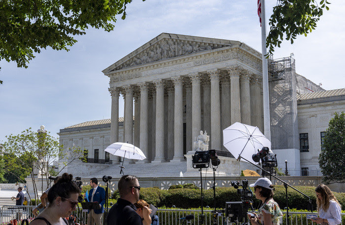 Journalists await decisions outside the U.S. Supreme Court on Wednesday, June 26, 2024, in Washington.