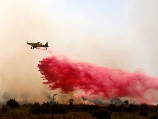 Un avion de lutte contre les incendies libère un retardateur de flamme pour éteindre les incendies provoqués par des roquettes lancées depuis le sud du Liban et qui ont atterri mercredi à la périphérie de Safed, en haute Galilée.