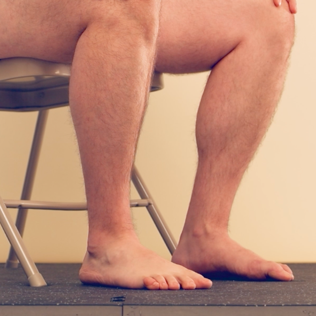 A video of a person sitting on a chair wiggling their bare toes.