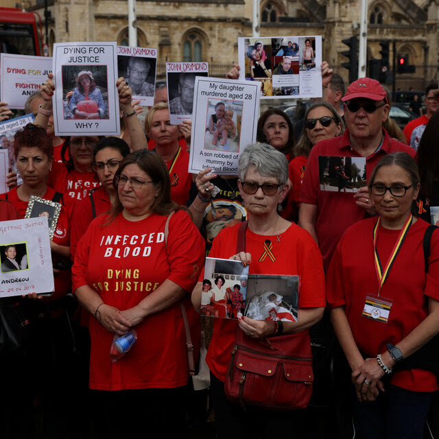 A group of red-shirted people, some with signs.