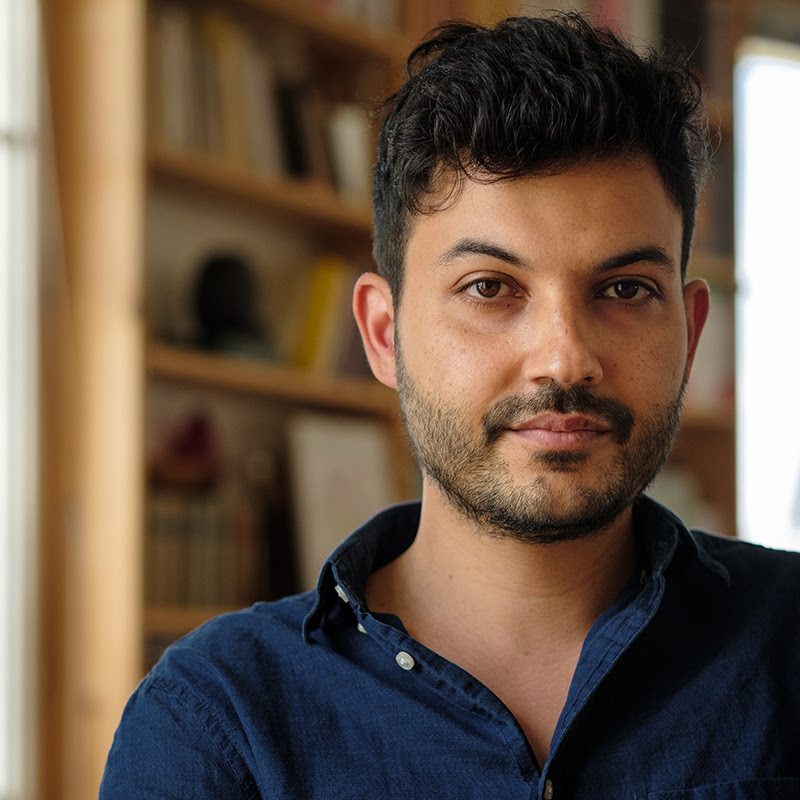 A man looks at the camera with a gentle smile.