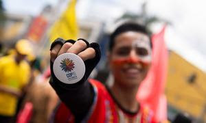 Un joven muestra un botón con la imagen oficial de la COP16 en una marcha de carnaval en Ibagué (Tolima). 