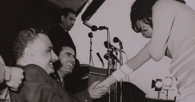 A young Libyan college student blushes after shaking hands with the then 29-year-old Qadhafi in 1970. Also seen in the picture is Egyptian leader, Abdel Nasser, who was on a visit to Libya.