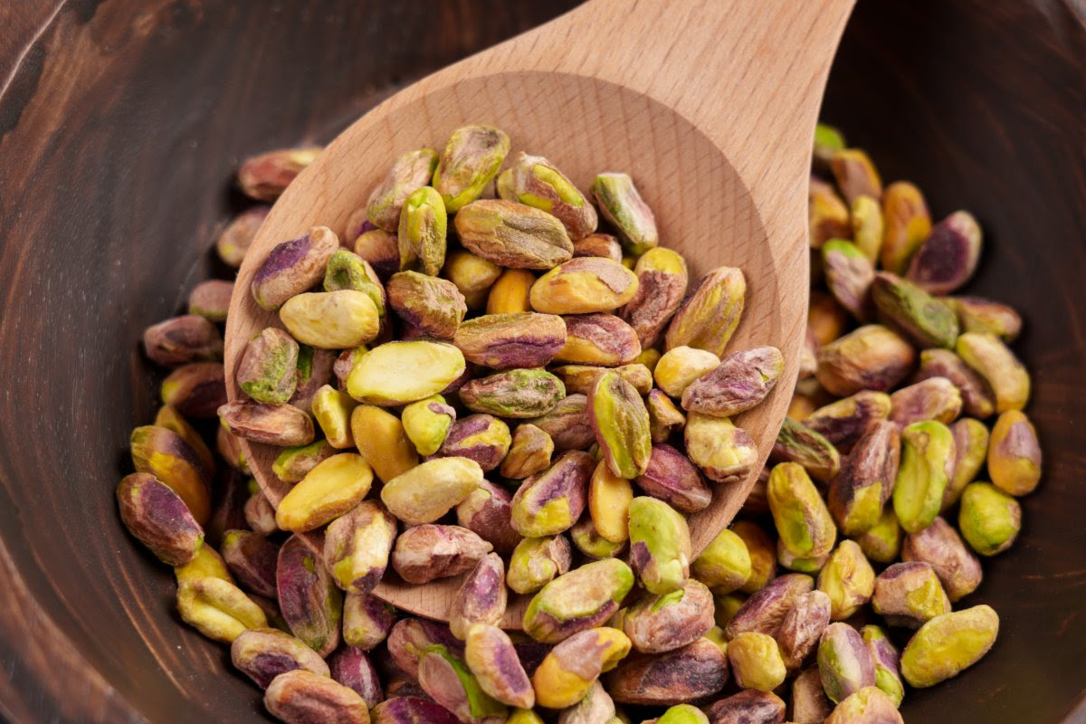 Shelled pistachio nuts in a wooden spoon