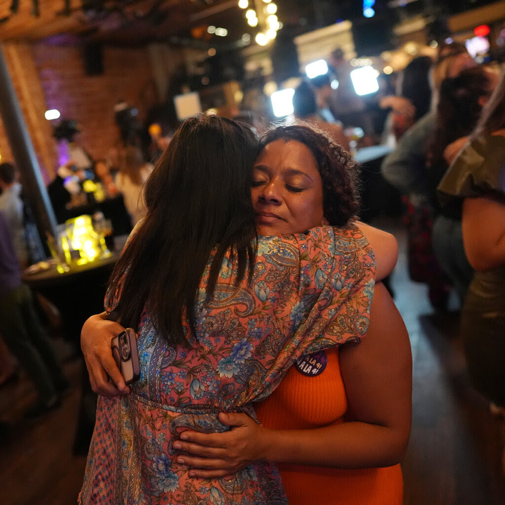 Two women embrace each other. 