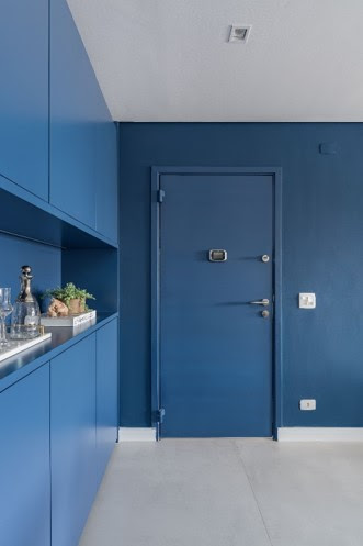 As paredes coloridas, com o mesmo tom de azul que colore o buffet e porta de entrada, criou um verdadeiro hall de entrada neste apartamento localizado no centro de São Paulo e trouxe um design moderno e inovador ao projeto, delimitando o ambiente do restante do imóvel. | Projeto: Spaço Interior | FOTO: Kadu Lopes