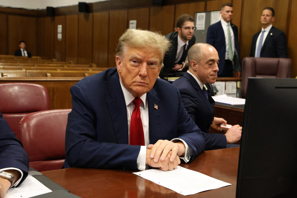 Donald Trump sits at a table in a Manhattan courtroom.