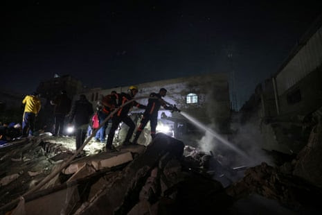 Firefighters spray water on the rubble of a building after Israeli bombardment in Rafah, in the southern Gaza Strip