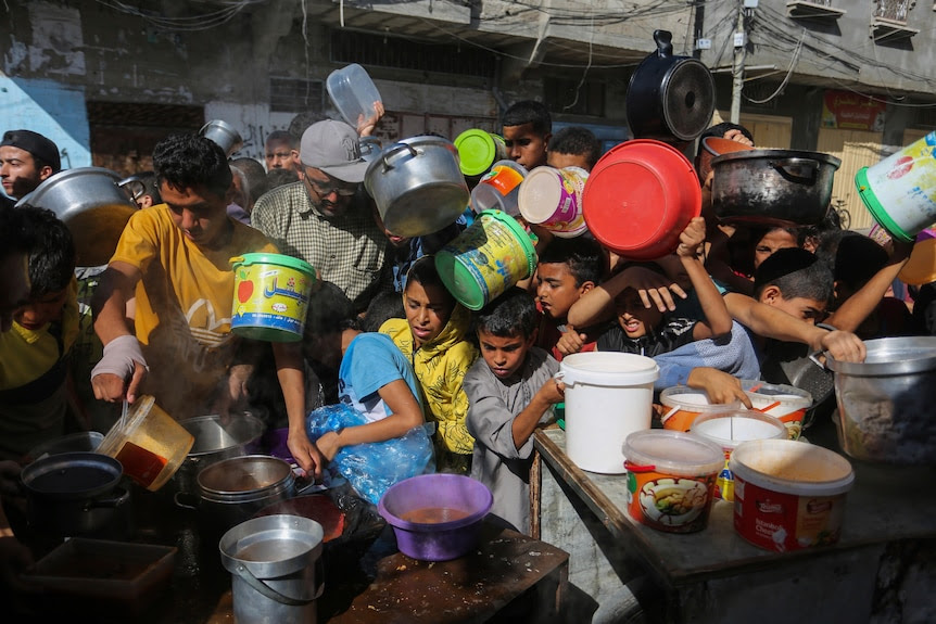 Palestinians crowd together as they wait for food distribution in Rafah, southern Gaza Strip. 