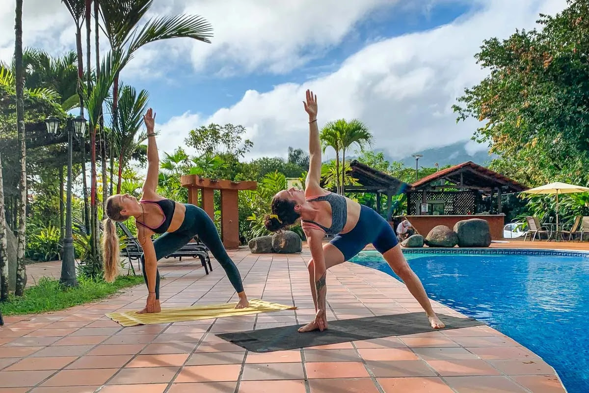 Bailey and her friend do yoga by the pool