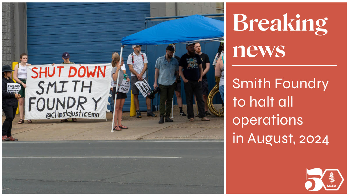 people standing in front of a wall holding a sign saying shut down smith foundry