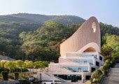 La iglesia se encuentra en un terreno inclinado al pie de una montaña, rodeada de bosques y con vistas panorámicas a la ciudad.