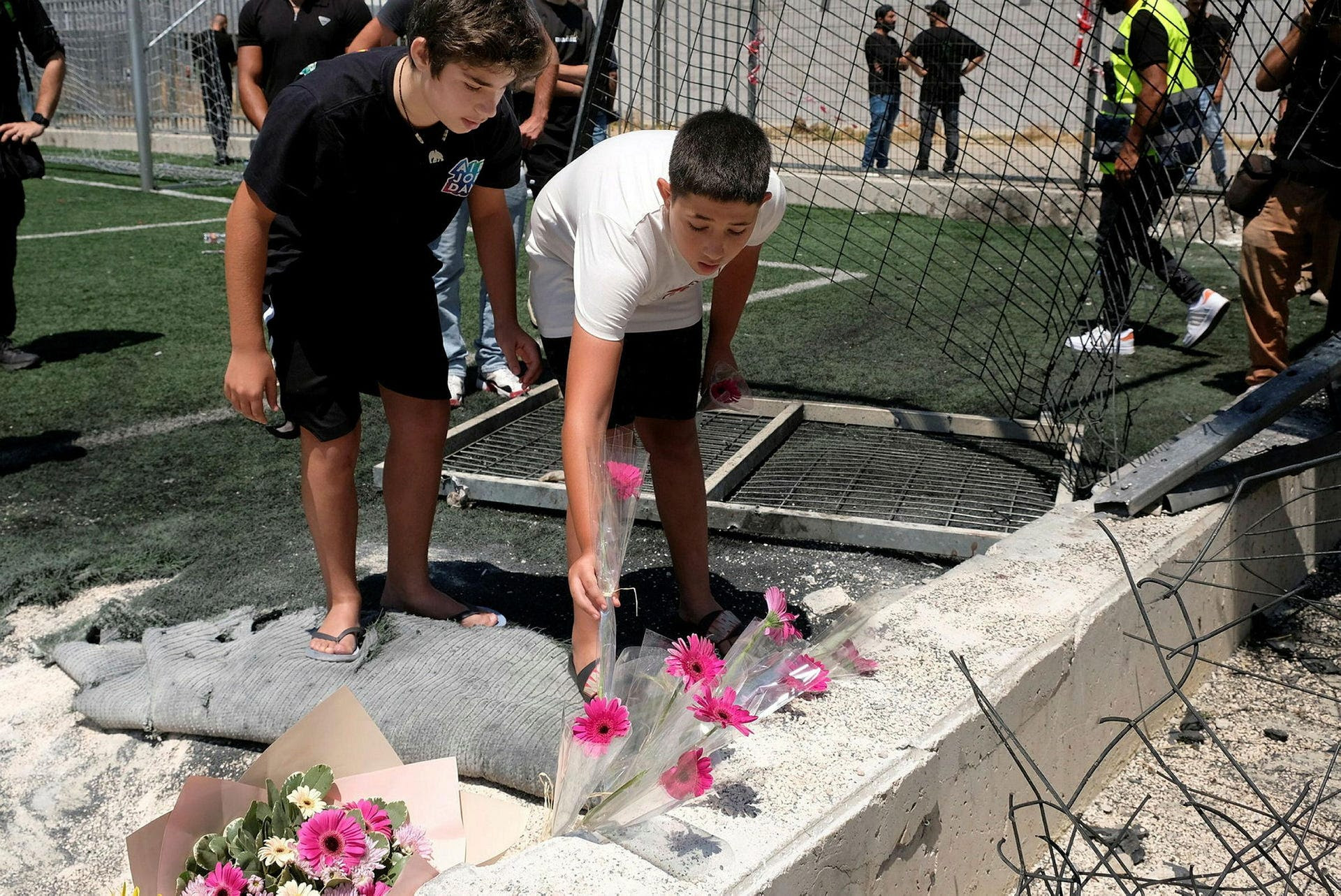 Children lay flowers at the spot where the rocket that killed 12 children in Majdal Shams landed, Sunday.