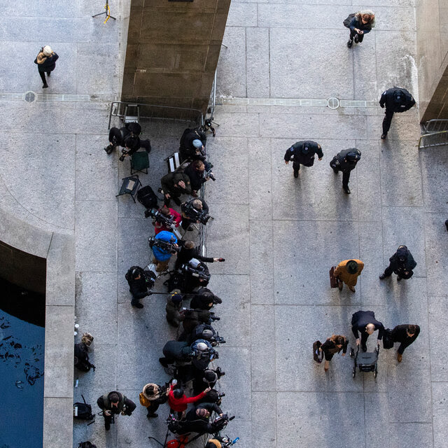 An overhead shot of journalists and Harvey Weinstein at a court building.