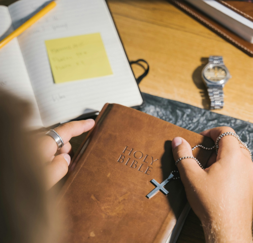 Hands holding a bible and rosary