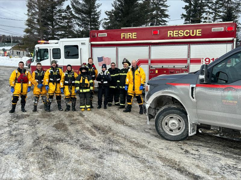 Rangers and Firefighters standing in front of a fire truck and a Forest Ranger truck