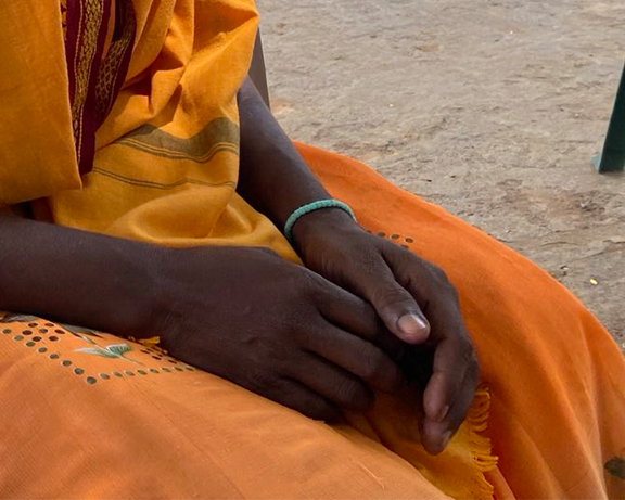 A photo of someone's hands resting on their laps