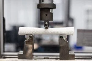 Researchers test a 3D-printed femur design in a universal testing machine, which measures a variety of properties.