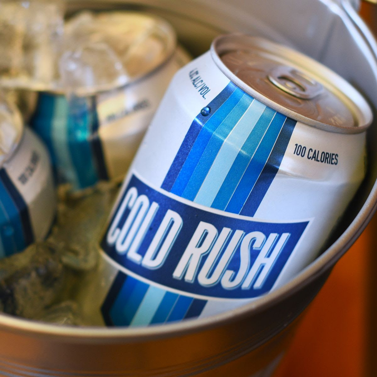 12 oz. Cans Cold Rush Premium Light Lager in a bucket of ice.